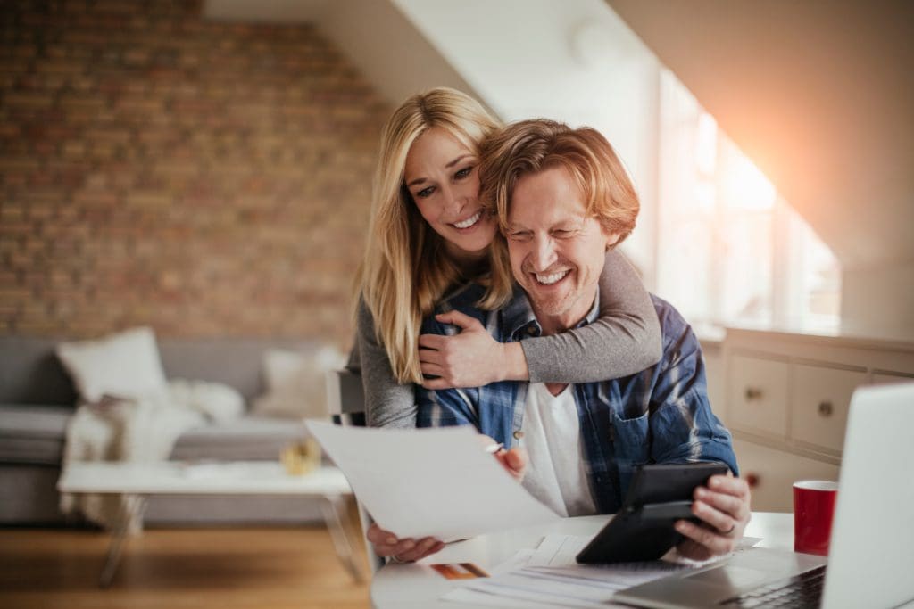 Mature couple going over their finances and bills at home while budgeting